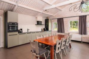 una cucina con tavolo e sedie in legno di Familiehuis met Hottub | 10 Pers. a Wilsum