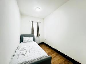 a bedroom with a bed in a white room at Apartment in East Ham, London in London