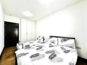 a bedroom with a bed with a black and white comforter at Apartment in East Ham, London in London