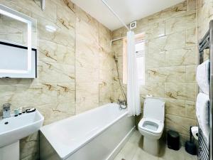 a bathroom with a tub and a toilet and a sink at Apartment in East Ham, London in London +1 photo