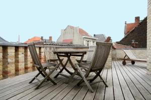 a wooden table topped with chairs next to a patio at Place 2 stay in Ghent
