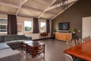 a living room with a couch and a table at Familiehuis met Hottub + trekkershutten | 18 Pers. in Wilsum