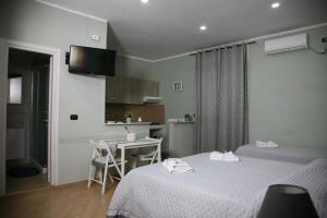 Una habitación de hotel con dos camas y cocina. en Locazione Ciampa, en Nápoles