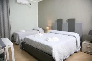 Una habitación de hotel con dos camas con toallas. en Locazione Ciampa, en Nápoles 23 fotos más