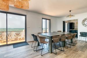 ein Esszimmer mit Tisch und Stühlen in der Unterkunft Villa Léa Vue mer d'exception Plage in Batz-sur-Mer