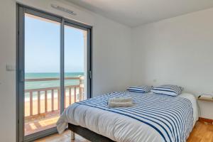 ein Schlafzimmer mit einem Bett mit Blick auf das Meer in der Unterkunft Villa Léa Vue mer d'exception Plage in Batz-sur-Mer