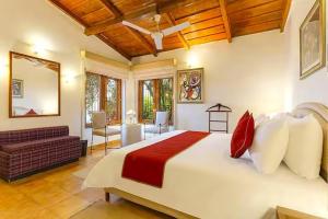 Un dormitorio con una cama grande y una sala de estar. en Lennys Nainital Hills 3 BD Garden Villa with Cook, en Bhowāli