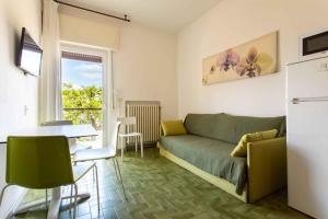 a living room with a green couch and a table at Villaggio Turistico Priori Malcesine in Malcesine