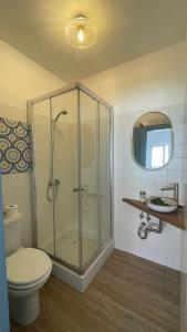 a bathroom with a shower with a toilet and a sink at Wild Souls Guesthouse in Ericeira +39 photos