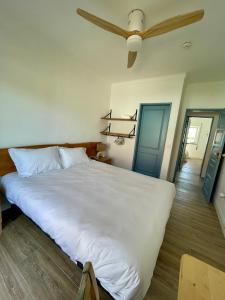a large white bed in a room with a ceiling fan at Wild Souls Guesthouse in Ericeira