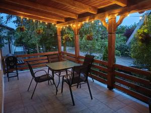 een houten terras met een tafel en stoelen erop bij Dom Letniskowy in Wielen Zaobrzanski
