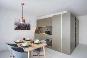 a kitchen and dining room with a wooden table and chairs at Contemporary Cosy Central Studio in Nyon - RM8 in Nyon +8 photos