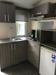 PeynierCamping 3 étoiles - Piscine - ccbbhgd的配有木质橱柜、水槽和炉灶的厨房
