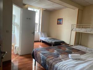 a bedroom with a bed and a bunk bed at Hotel Du Commerce in Auxerre