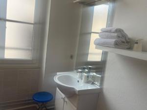 a white bathroom with a sink and a mirror at Hotel Du Commerce in Auxerre