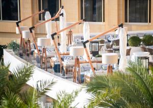 een restaurant met witte parasols en tafels en stoelen bij InterContinental Doha Beach & Spa by IHG in Doha +37 foto's