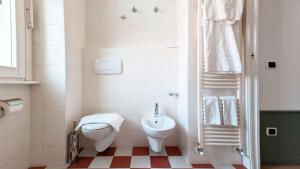a white bathroom with a toilet and a sink at Residence la Limonera in Bellagio