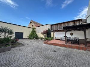 ノイシュタット・アン・デア・ヴァインシュトラーセにあるBig Apple House - 3 bedrooms with Promotion for longer stayの建物の中にテーブルと椅子が置かれたパティオ