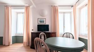 a dining room with a table and a television at Residence la Limonera in Bellagio