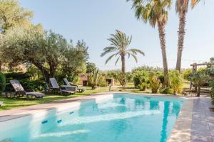 a swimming pool in a yard with palm trees at Casa Blandina in Menfi +32 photos