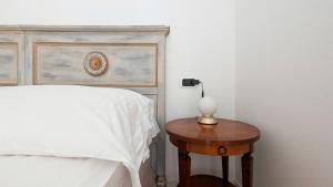 a bedroom with a bed and a table with a lamp at Residence la Limonera in Bellagio