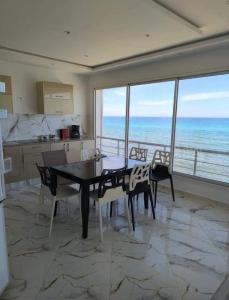 a dining room with a table and a view of the ocean at Appart Rafraf Sounine in Ibn Khaldoun +43 photos