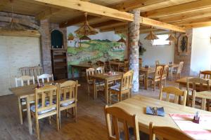 ein Restaurant mit Holztischen und -stühlen und einem Wandbild in der Unterkunft Penzion u Tomčalů in Terezín