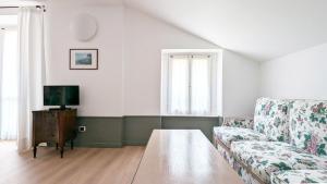 a living room with a couch and a tv at Residence la Limonera in Bellagio