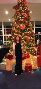 a woman standing in front of a christmas tree at Maria's Cosy Haven in Barataria