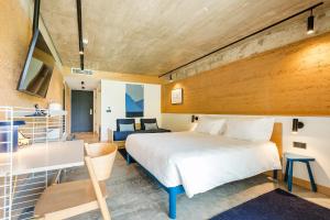 a bedroom with a bed and a desk and a couch at Gandum Village - Conscious Boutique Hotel in Montemor-o-Novo