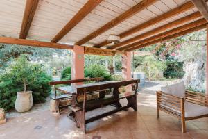 a wooden pergola with a table and a bench at Casa Blandina in Menfi