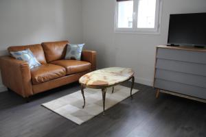 a living room with a couch and a coffee table at Cosy Apparts Suresnes La Défense in Suresnes
