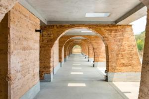 una arcada de un edificio con una pared de ladrillos en Gandum Village - Conscious Boutique Hotel, en Montemor-o-Novo