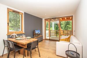a dining room with a table and chairs and a couch at FLORA ALPINA EXPERIENCE - "Ski-to-Door" Brand New Chalet Apartments with Indoor Garage and Mountain View in Breuil-Cervinia