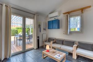a living room with a couch and a table at Maison Frontignan Plage Piscine in Frontignan