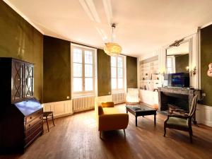 a living room with a yellow couch and a tv at L'imparfait - Maison 5 chambres - Home République in Auxerre
