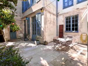 a patio with a table and chairs in front of a building at L'imparfait - Maison 5 chambres - Home République in Auxerre