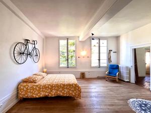 a bedroom with a bed and a bicycle on the wall at L'imparfait - Maison 5 chambres - Home République in Auxerre