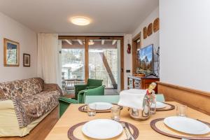 a living room with a table and a couch at FLORA ALPINA EXPERIENCE - "Ski-to-Door" Brand New Chalet Apartments with Indoor Garage and Mountain View in Breuil-Cervinia