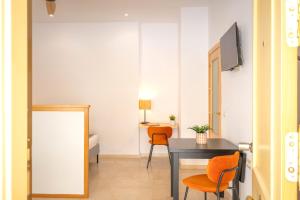 - une salle à manger avec une table et deux chaises orange dans l'établissement ISG Apartments Estudio en La Alameda, à Séville 33 autres photos