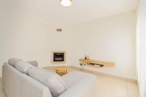 a white living room with a couch and a table at Villa Lavanda in Calpe