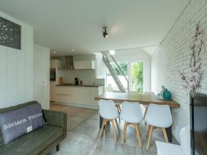 a kitchen and living room with a table and chairs at Family Home near Dunes and Beach in Sint Maartensvlotbrug