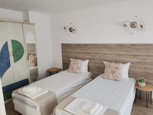 two beds in a room with a wooden wall at Family Hotel Rai in Shumen