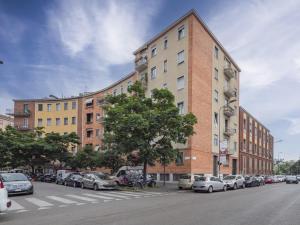 un edificio con auto parcheggiate sul lato di una strada di Città Studi design apartments by Rentopolis a Milano