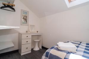 a white bedroom with a bed and a desk at Penthouse City Centre Apartment in Royal Tunbridge Wells