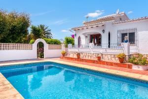 a villa with a swimming pool in front of a house at Villa Jeannine in El Tosalet