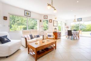 a living room with a white couch and a table at Spacieuse maison à 200m de la plage in Combrit