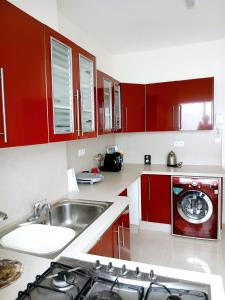 une cuisine avec des armoires rouges et un évier dans l'établissement Chez Nouzha, à Tanger