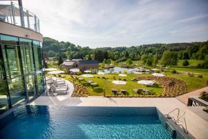 ein Außenpool mit Blick auf ein Resort in der Unterkunft Pfalzblick Wald Spa Resort in Dahn