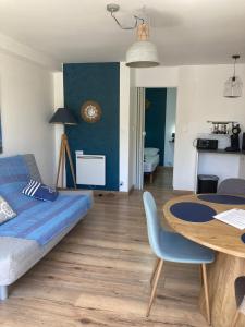 una sala de estar con una cama y una mesa en VILLA DEL RE 1 dans résidence avec piscine, en La Flotte